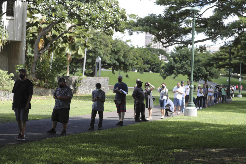 FILE - In this Nov. 3, 2020, file photo, a long line of people waiting to vote stretches around City Hall on Election Day, in Honolulu. Voter advocates say Hawaii should set up more voter service centers after a last-minute surge of voter interest led to hours-long lines for in-person voting on Election Day even as the state shifted to a vote-by-mail system for casting ballots. (AP Photo/Marco Garcia, File)