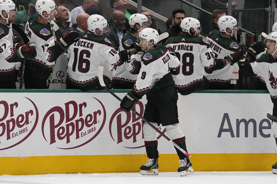 Arizona Coyotes right wing Clayton Keller (9) celebrates with the bench after scoring against the Dallas Stars in the first period of an NHL hockey game, Tuesday, Nov. 14, 2023, in Dallas. (AP Photo/Tony Gutierrez)