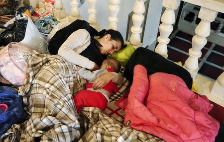 A migrant from Syria breastfeeds her baby inside a mosque in Kumanovo, Macedonia, close to the Serbian border, June 18, 2015. REUTERS/Ognen Teofilovski