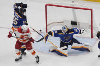 St. Louis Blues goaltender Jordan Binnington (50) deflects a puck away from Calgary Flames' Connor Zary (47) during the second period of an NHL hockey game Thursday, March 28, 2024, in St. Louis. (AP Photo/Jeff Roberson)