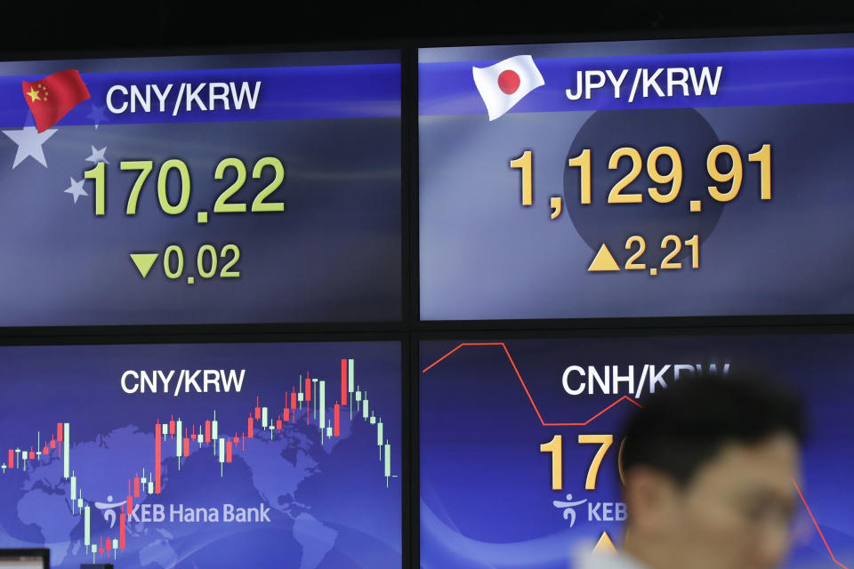 A currency trader walks near screens showing the foreign exchange rates at the foreign exchange dealing room in Seoul, South Korea, Thursday, Aug. 22, 2019. Asian stock markets are mixed Thursday following Wall Street’s rebound as investors looked ahead to a speech by the U.S. Federal Reserve chairman for clues about possible interest rate cuts. (AP Photo/Lee Jin-man)