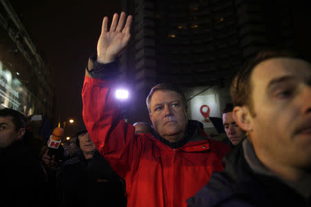 Romanian President Klaus Iohannis waves to protesters gathered at a demonstration against government plans to grant prison pardons and decriminalize some offences through emergency decree, in Bucharest, Romania, January 22, 2017. Inquam Photos/Liviu Florin Albei via REUTERS