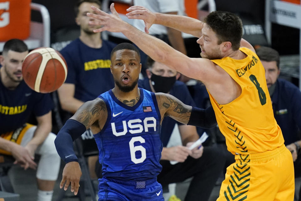 United States' Damian Lillard passes around Australia's Matthew Dellavedova during an exhibition basketball game Monday, July 12, 2021, in Las Vegas. (AP Photo/John Locher)