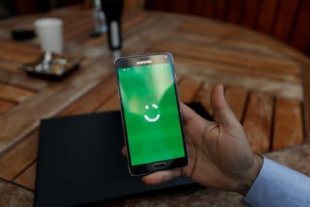 FILE PHOTO: An employee shows the logo of ride-hailing company Careem on his mobile in his office in the West Bank city of Ramallah July 17, 2017. Picture taken July 17, 2017. REUTERS/Mohamad Torokman/File Photo