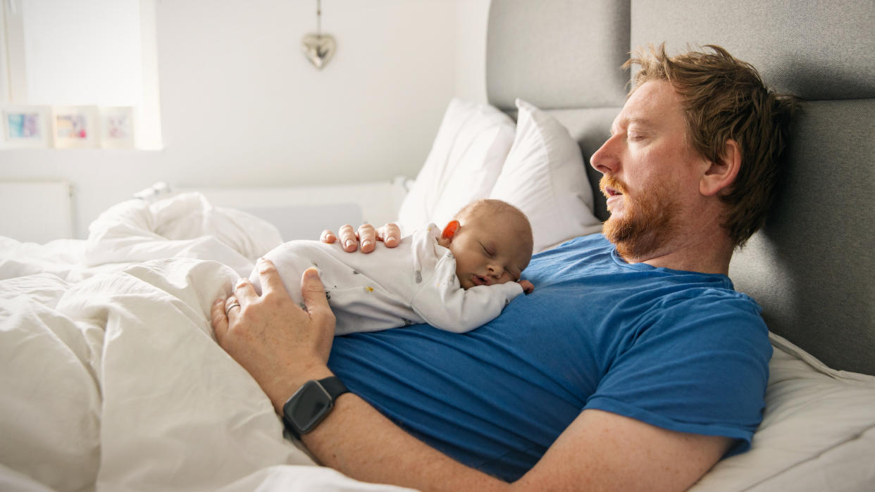  Father with infant asleep on chest. 