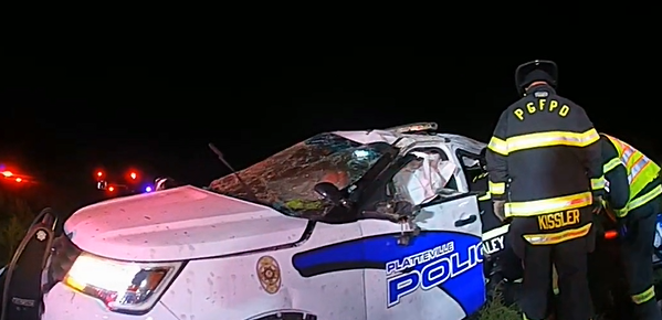 A destroyed police car at night