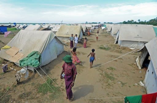 Muslim Rohingya people walk around the Bawdupha Internally Displaced Persons (IDP) camp on the outskirts of Sittwe on November 2. The UN's refugee agency has begun airlifting tents to provide shelter for thousands of people displaced by sectarian unrest in Myanmar's western Rakhine State