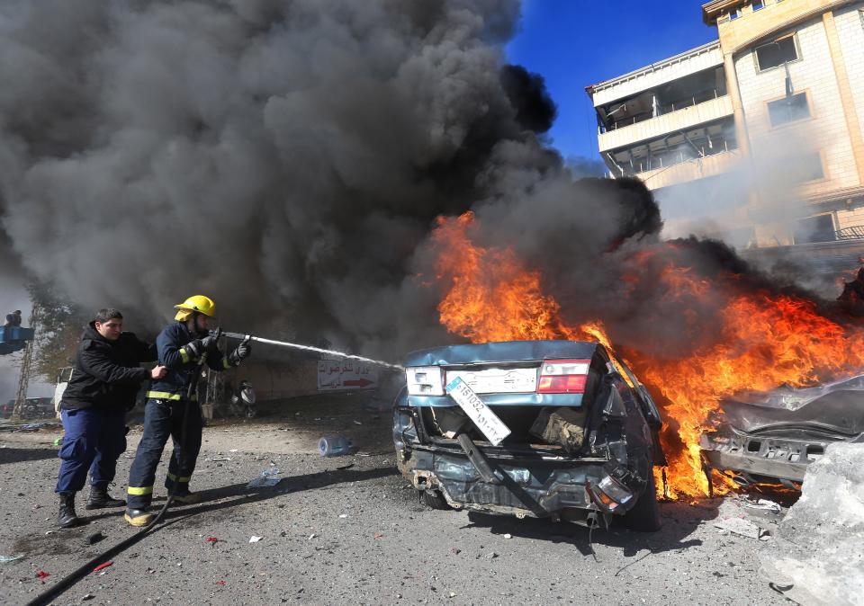 Lebanese firefighters extinguish a burned car at the site of an explosion, in the suburb of Beir Hassan, Beirut, Lebanon, Wednesday Feb. 19, 2014. A blast in a Shiite district in southern Beirut killed at several people on Wednesday, security officials said — the latest apparent attack linked to the civil war in neighboring Syria that has killed and wounded scores of people over the last few months. (AP Photo/Hussein Malla)