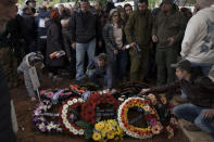 Family and friends of Israeli reservist warrant officer Yuval Nir mourn over his grave during his funeral at a cemetery in the West Bank settlement of Kfar Etzion, Israel, Wednesday, Jan. 31, 2024. Nir, 43, was killed during Israel's ground operation in the Gaza Strip, where the Israeli army has been battling Palestinian militants in the war ignited by Hamas' Oct. 7 attack into Israel. (AP Photo/Leo Correa)