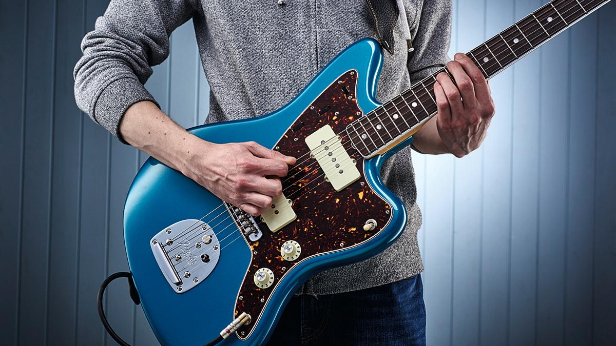  Person playing a power chord on an electric guitar 