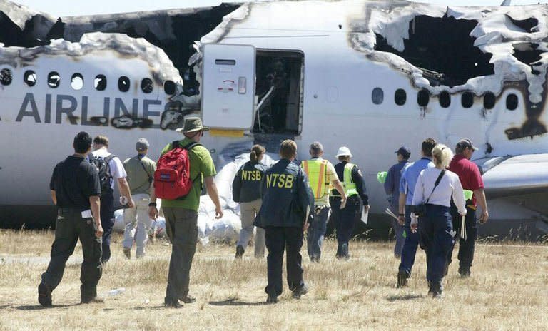 Investigators inspect the wreckage of Asiana Flight 214 in San Francisco, July 7, 2013. Investigators probing the Asiana Airlines plane crash began interviewing cockpit crew of the Boeing 777 amid mounting indications that pilot error may have caused the fatal accident