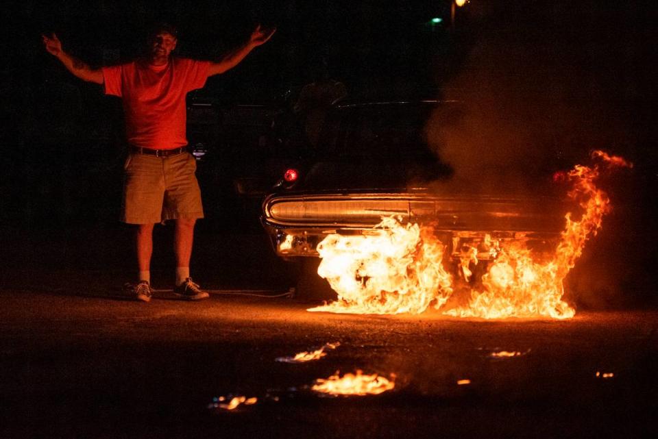 Jason Hamilton reacts as his 1962 Mercury Monterey shoots flames of the tailpipes during a flame throwing competition, where drivers compete to see which car can produce the biggest flames, at Island View Casino in Gulfport during Cruisin’ The Coast on Tuesday, Oct. 3, 2023.