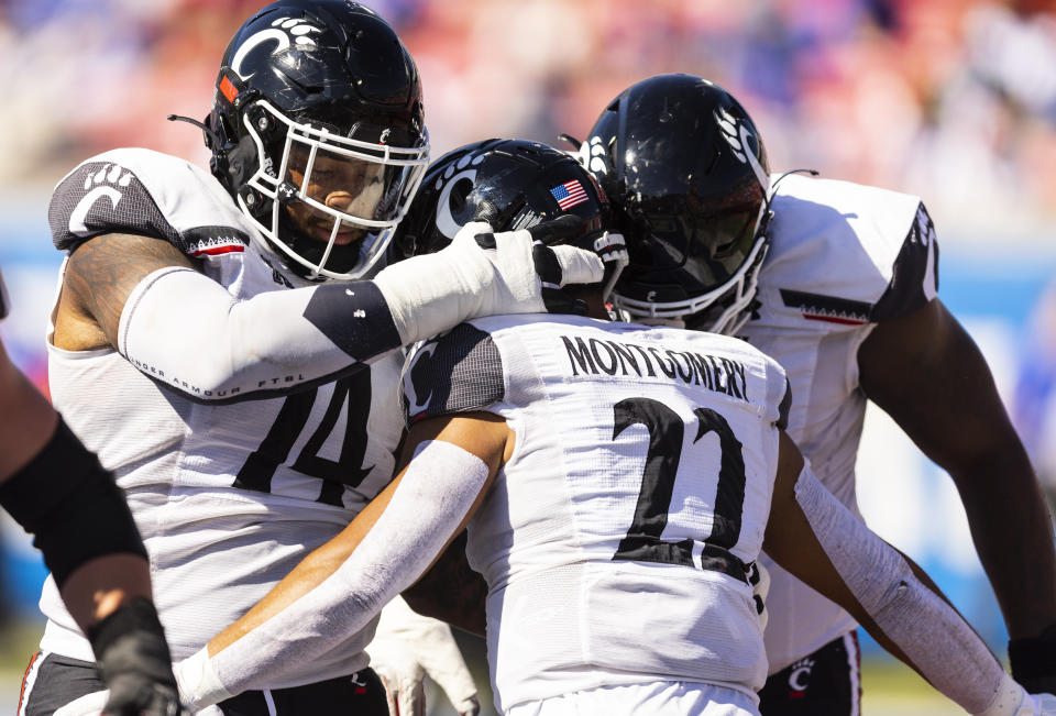 Cincinnati running back Ryan Montgomery (22) is congratulated by teammates after scoring a touchdown during the first half of an NCAA college football game against SMU, Saturday, Oct. 22, 2022, in Dallas. (AP Photo/Brandon Wade)