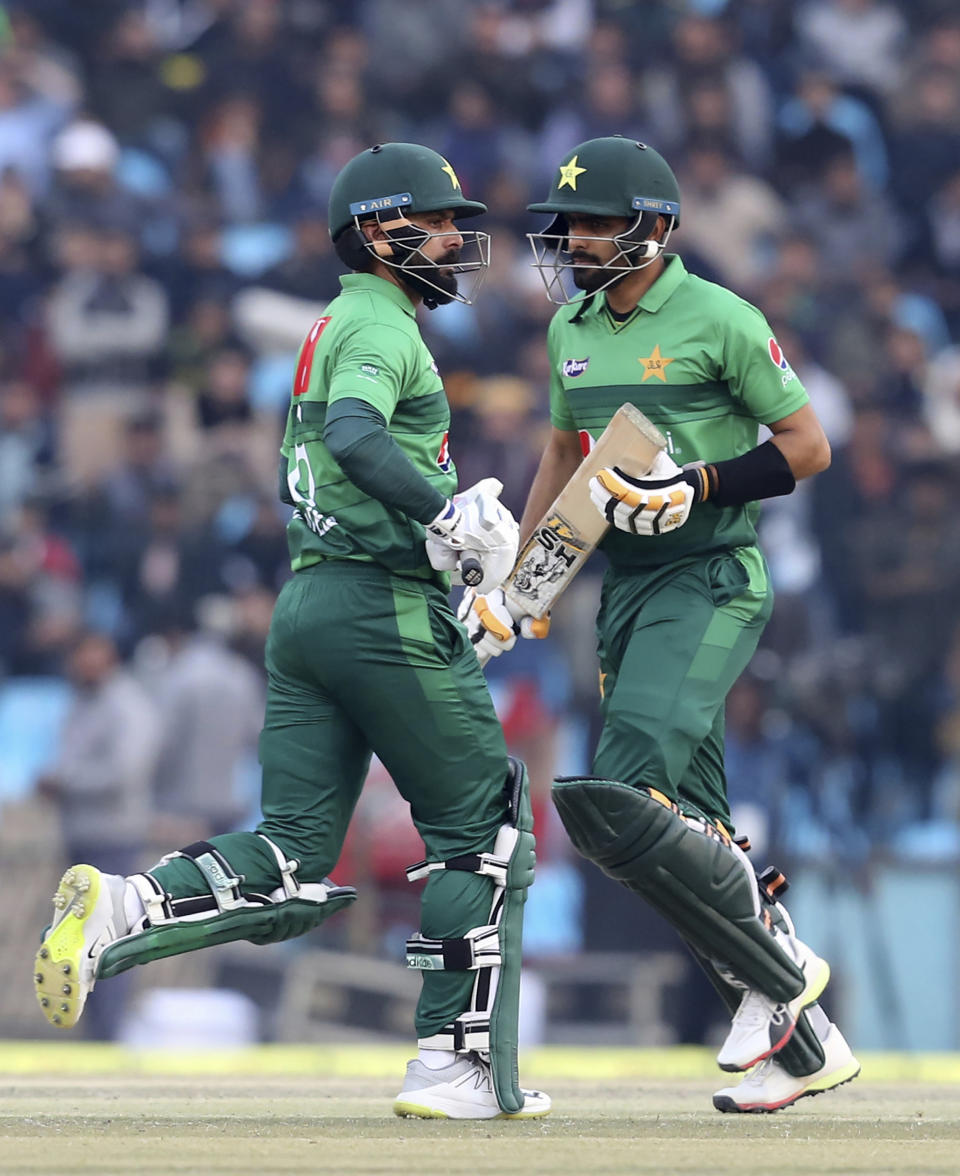 Pakistan batsmen Babar Azam, right, and Mohammad Hafeez run between the wicket during the second T20 cricket match against Bangladesh at Gaddafi stadium, in Lahore, Pakistan, Saturday, Jan. 25, 2020. (AP Photo/K.M. Chaudary)