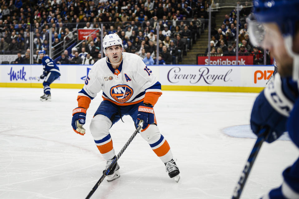 Toronto Maple Leafs defenseman Morgan Rielly, right, is defended by New York Islanders right wing Cal Clutterbuck (15) during first-period NHL hockey game action in Toronto, Monday, Nov. 21, 2022. (Christopher Katsarov/The Canadian Press via AP)