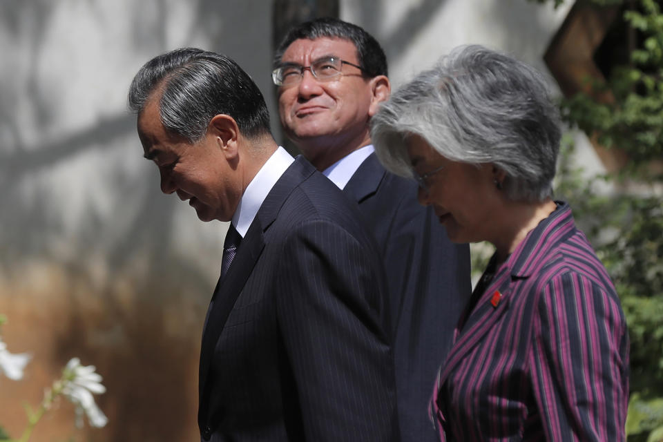 Chinese Foreign Minister Wang Yi, left, walks with his Japanese counterpart Taro Kono, center, and South Korean counterpart Kang Kyung-wha for a joint press conference after their trilateral meeting at Gubei Town in Beijing Wednesday, Aug. 21, 2019. (Wu Hong/Pool Photo via AP)