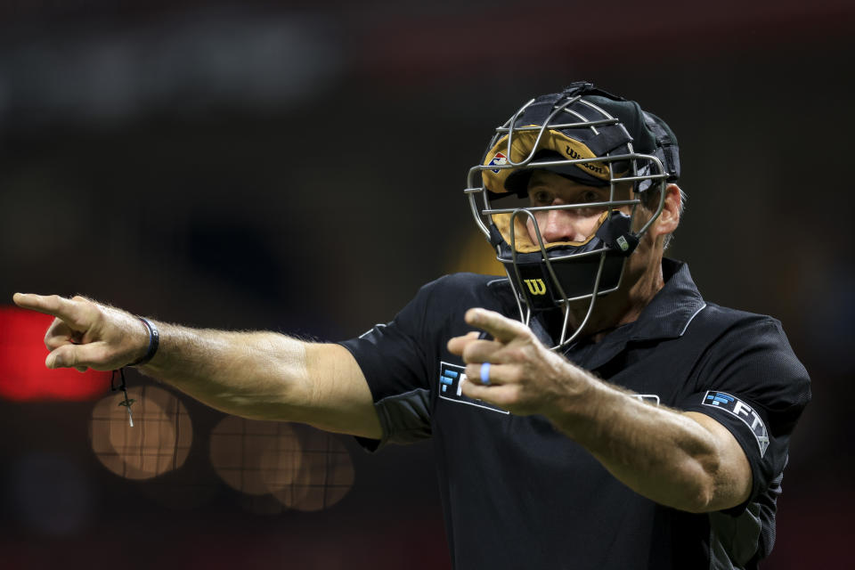 FILE - MLB umpire Angel Hernandez signals during a baseball game between the Arizona Diamondbacks and the Cincinnati Reds in Cincinnati, June 8, 2022. Longtime umpire Hernández, who unsuccessfully sued Major League Baseball for racial discrimination, is retiring immediately, announced Monday, May 27, 2024. (AP Photo/Aaron Doster, File)