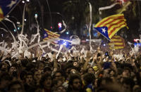 Demonstrators throw paper toilet rolls into the air during a protests in Barcelona, Spain, Wednesday, Oct. 16, 2019. Protesters in Barcelona are throwing hundreds of white paper toilet rolls into the air to show their anger over lengthy prison sentences given to separatist Catalan leaders. The demonstration Wednesday evening in the Catalan capital is the third straight day of protests since the Supreme Court handed down the sentences. (AP Photo/Emilio Morenatti)