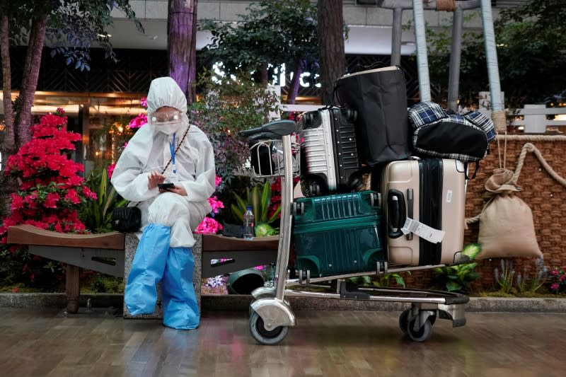 A Chinese woman, wearing full protective gear to prevent contracting the coronavirus, waits for her flight at Incheon International Airport