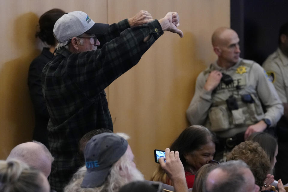 A man gives the thumbs down to the Maricopa County Board of Supervisors during their general election canvass meeting, Monday, Nov. 28, 2022, in Phoenix. (AP Photo/Matt York)