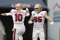 San Francisco 49ers tight end George Kittle (85) celebrates with quarterback Jimmy Garoppolo (10) after scoring a touchdown against the Seattle Seahawks during the first half of an NFL football game, Sunday, Dec. 5, 2021, in Seattle. (AP Photo/John Froschauer)