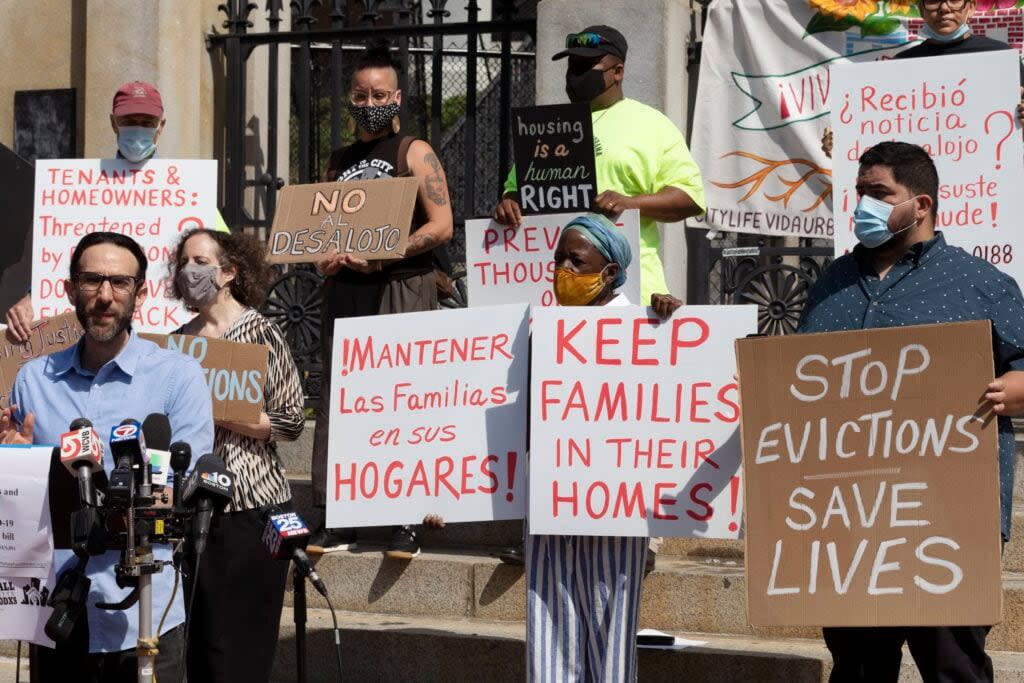 People hold signs protesting evictions during a news conference on Friday, July 30, 2021, in Boston. (AP Photo/Michael Dwyer)