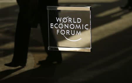 A man walks past the official logo of the World Economic Forum (WEF) in Davos, Switzerland January 16, 2017. REUTERS/Ruben Sprich