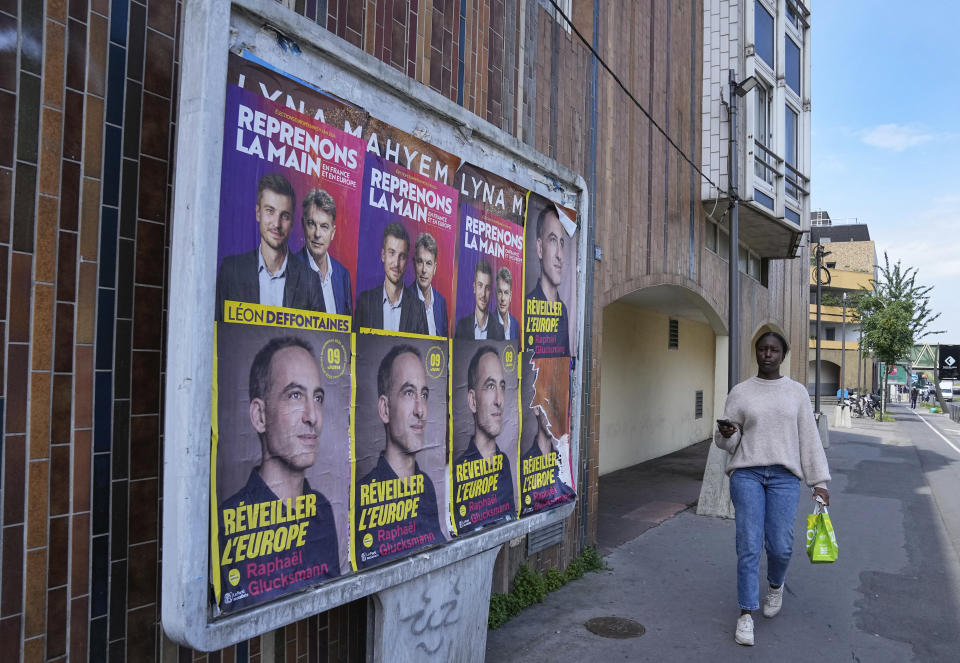Una mujer pasa junto a carteles electorales para los comicios al Parlamento Europeo, en Colombes, al oeste de París, el 6 de junio de 2024. (AP Foto/Michel Euler)