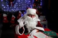 Nemes, dressed as Santa, waves as he interacts with children by video in a photo studio, amid the COVID-19 outbreak in Budapest