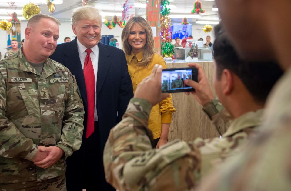 US President Donald Trump and First Lady Melania Trump take photos with members of the US military during an unannounced trip to Al Asad Air Base in Iraq on December 26, 2018. - President Donald Trump arrived in Iraq on his first visit to US troops deployed in a war zone since his election two years ago (Photo by SAUL LOEB / AFP)SAUL LOEB/AFP/Getty Images ORG XMIT: US Presid ORIG FILE ID: AFP_1BU3JR