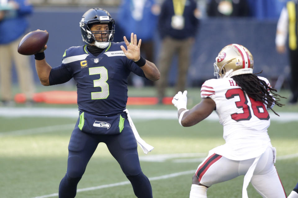 Seattle Seahawks quarterback Russell Wilson (3) makes a touchdown pass to wide receiver DK Metcalf (not shown) as San Francisco 49ers safety Marcell Harris, right, pressures during the first half of an NFL football game, Sunday, Nov. 1, 2020, in Seattle. (AP Photo/Scott Eklund)