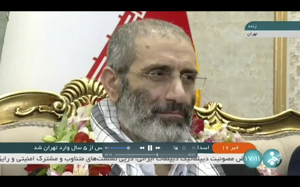 In this frame grab from video footage released Friday, May 26, 2023, by Iran state TV, IRINN, Assadollah Assadi, an Iranian diplomat who was released in a prisoner swap with Belgium, sits upon arrival at the Mehrabad airport in Tehran, Iran. Belgium and Iran exchanged prisoners on Friday in a controversial move that saw an Iranian diplomat convicted of attempting to bomb exiles in France bedecked in flowers on his return to Tehran while an aid worker was heading back to Brussels. (IRINN via AP)