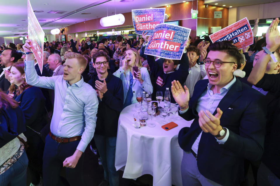 Supporters and party members of the CDU cheer at the election party after the first forecasts for the state election in Schleswig-Holstein were announced, In Kiel, Germany, Sunday, May 8, 2022. (Christian Charisius/dpa via AP)