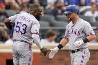 Texas Rangers' Kole Calhoun, right, celebrates with Adolis Garcia (53) after hitting a three-run home run off New York Mets starting pitcher Trevor Williams (29) in the second inning of a baseball game, Saturday, July 2, 2022, in New York. (AP Photo/John Minchillo)