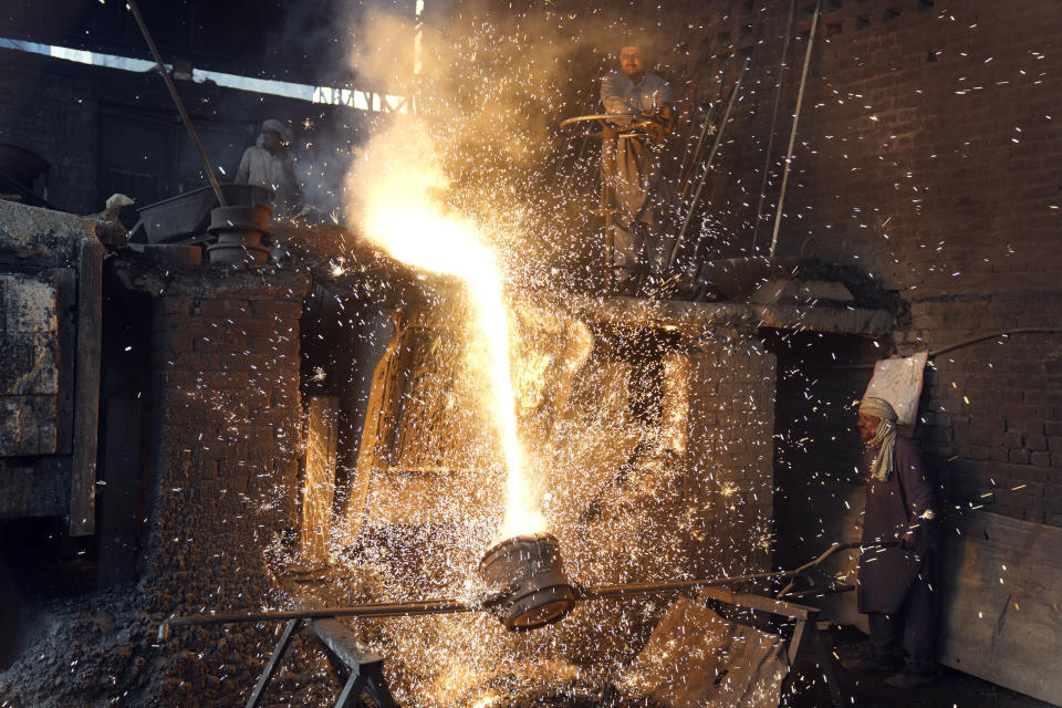 Laborers pour molten metalcin a steel factory in Lahore, Pakistan, Saturday, April 29, 2023. (AP Photo/K.M. Chaudary)