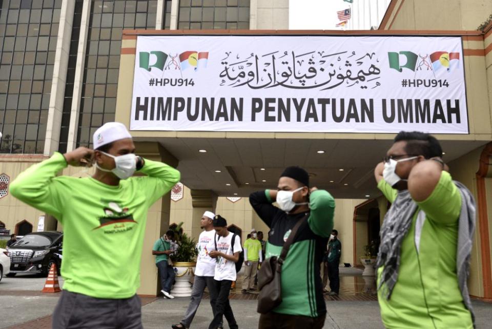 People cover their faces with masks outside the Putra World Trade Centre in Kuala Lumpur September 13, 2019. — Picture by Miera Zulyana