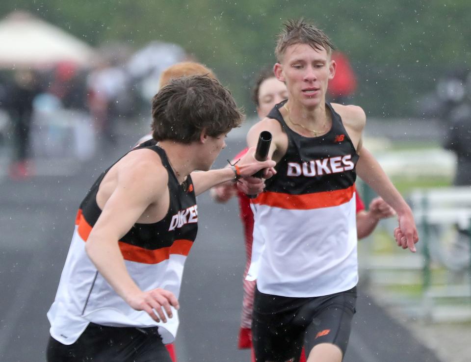 Marlington's Logan Citino (right) hands the baton to Colin Cernansky during the boys 3,200-meter relay at last week's Eastern Buckeye Conference Track and Field Championships.