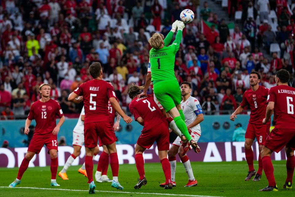 Denmark's goalkeeper Kasper Schmeichel, top, clears the ball during the World Cup group D football match between Denmark and Tunisia, at the Education City Stadium in Al Rayyan, Qatar, Tuesday, Nov. 22, 2022. (AP Photo/Manu Fernandez)