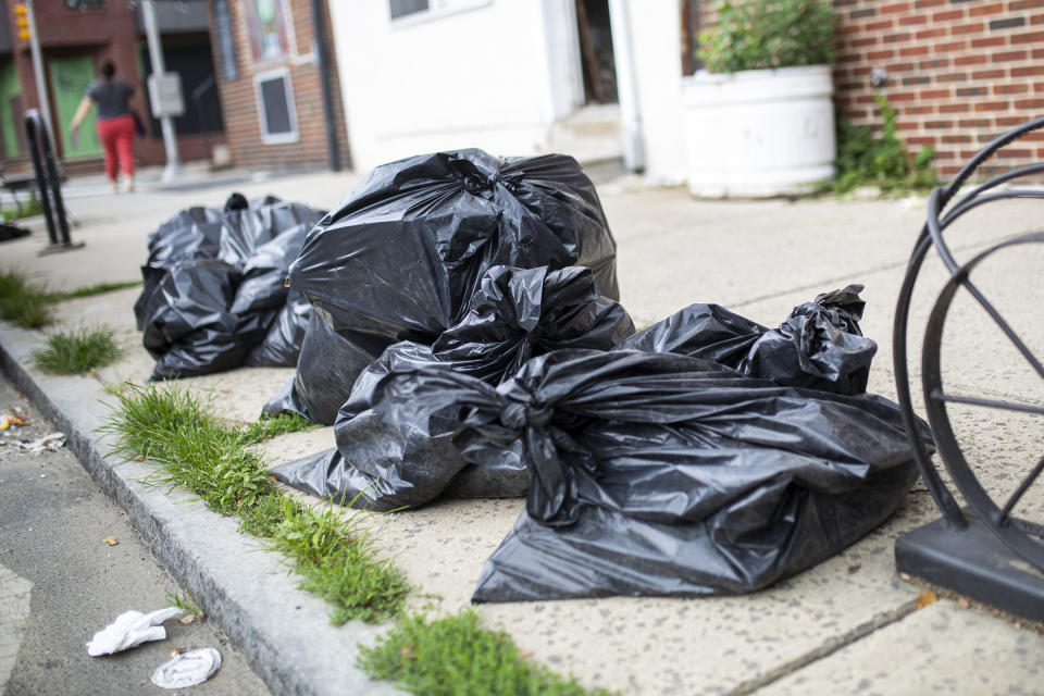 In this photo from July 17, 2020, trash left to be picked up is on the sidewalk in the Fishtown neighborhood of Philadelphia along Frankford Avenue. The city's 311 complaint line has received 9,753 calls about trash and recycling as of July 29 compared to 1,873 in February. (Tyger Williams/The Philadelphia Inquirer via AP)