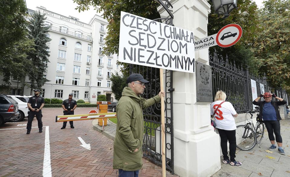 Protesters with banners calling on Justice Minister Zbigniew Ziobro to quit over allegations that his deputy encouraged an online hate campaign against defiant judges in Warsaw, Poland, Wednesday, Aug. 21, 2019. The deputy, Lukasz Piebiak, has resigned over the allegations but said they were libel that he will take to court. The banner reads"Respect and Glory to Steadfast Judges". (AP Photo/Czarek Sokolowski)