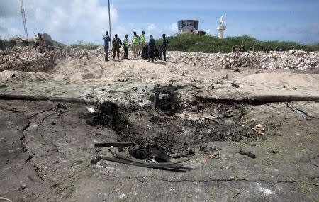 Somali policemen and miltary gather near the scene of a suicide bombing near the African Union's main peacekeeping base in Mogadishu, Somalia, July 26, 2016. REUTERS/Ismail Taxta