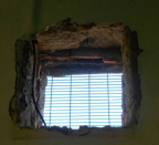 <p>A hole to the outside in the wall of an occupied cell. (Life in prison: Living conditions report) </p>