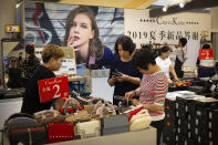 Shoppers browse goods for sale at a discount retailer in a shopping mall in Beijing, Friday, Aug. 2, 2019. China has announced it will raise tariffs on $75 billion of U.S. products in retaliation for President Donald Trump's planned Sept. 1 duty increase in a war over trade and technology policy. (AP Photo/Mark Schiefelbein)