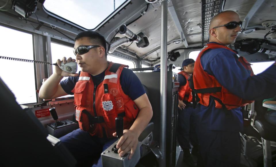 This photo taken Jan. 28, 2014, Coast Guard officer William Pless communicates on the radio while steering the 45 foot Coast Guard vessel through a dense fog during a patrol off the San Diego coast in San Diego. With the drug war locking down land routes across Latin America and at the U.S. border, smugglers have been increasingly using large vessels to carry multi-ton loads of cocaine and marijuana hundreds of miles offshore, where the lead federal agency with extensive law enforcement powers is the Coast Guard, a military service roughly the size of the New York Police Department. (AP Photo/Lenny Ignelzi)