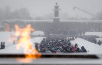 People walk in snowfall from the eternal flame to the Motherland monument to place flowers at the Piskaryovskoye Cemetery where most of the Leningrad Siege victims were buried during World War II, in St.Petersburg, Russia, Saturday, Jan. 26, 2019. People gathered to mark the 75th anniversary of the battle that lifted the Siege of Leningrad. The Nazi German and Finnish siege and blockade of Leningrad, now known as St. Petersburg, was broken on Jan. 18, 1943 but finally lifted Jan. 27, 1944. More than 1 million people died mainly from starvation during the 900-day siege. (AP Photo/Dmitri Lovetsky)