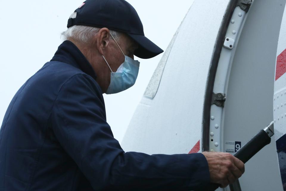 Wearing two face masks to reduce the risk posed by the coronavirus, Democratic presidential nominee Joe Biden boards a flight to Michigan at New Castle County Airport October 16, 2020 in New Castle, Delaware.