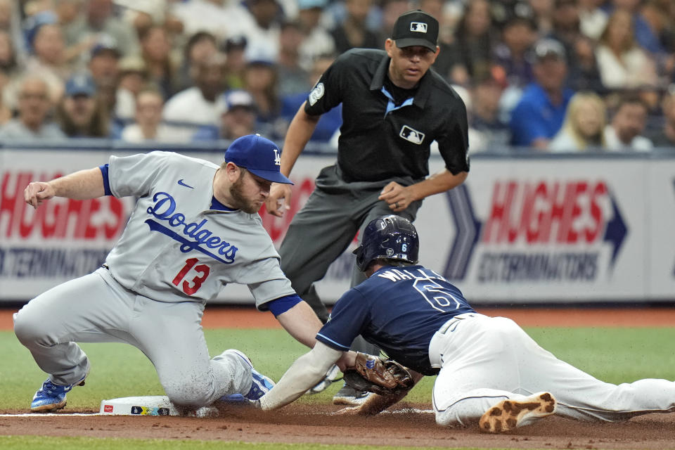 Tampa Bay Rays' Taylor Walls (6) steals third base as Los Angeles Dodgers third baseman Max Muncy (13) is late with the tag during the third inning of a baseball game Saturday, May 27, 2023, in St. Petersburg, Fla. (AP Photo/Chris O'Meara)