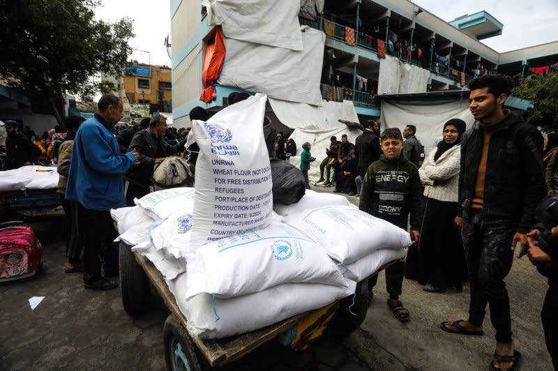 Displaced Palestinians receive bags of flour at the United Nations Relief and Works Agency for Palestine Refugees school in Rafah in the southern Gaza Strip on Sunday. Photo by Ismael Mohamad/UPI