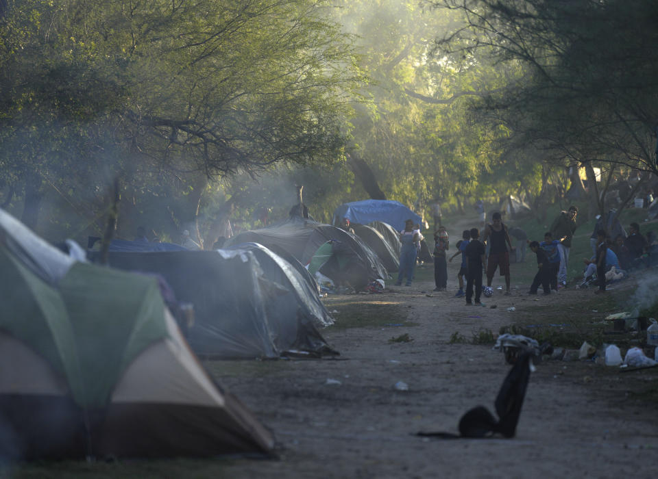 Venezuelan migrants play soccer at a makeshift campson a river bank in Matamoros, Mexico, Thursday, Dec. 22, 2022. (AP Photo/Fernando Llano)