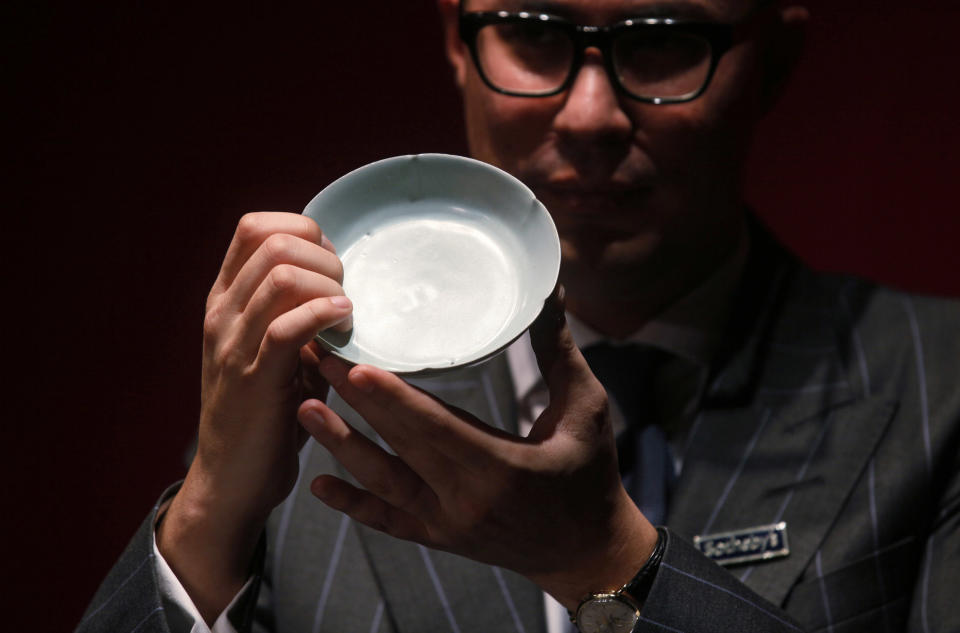 Nicolas Chow, Sotheby’s Asia Deputy Chairman, holds the Chinese Song Dynasty ceramics Ruyao Washer at the Sotheby's auction in Hong Kong Wednesday, April 4, 2012. The 900-year-old dish smashed the world record for Chinese Song Dynasty ceramics sold at auction, fetching US$26.7 million. (AP Photo/Kin Cheung)
